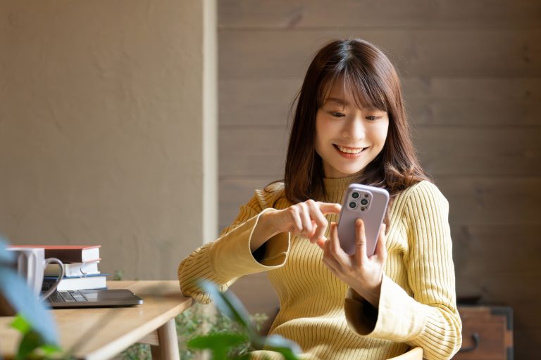カフェでスマートフォンを操作する女性