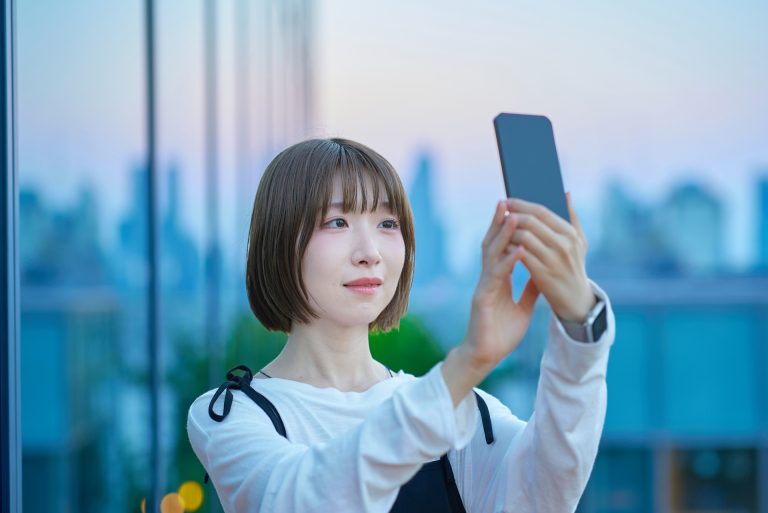 スマートフォンを掲げる女性