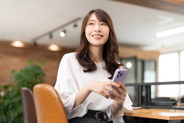 スマートフォンを手に微笑む女性